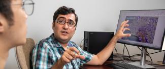 Dr. Ebrahim Ahmadisharaf discussing his research, pointing a map of Panama City, Florida